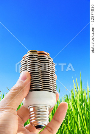 hand holding coin light bulb 12874056
