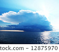 Bright blue sky with stormy clouds over a calm sea 12875970