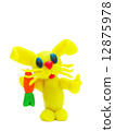 Yellow plasticine rabbit with carrot 12875978
