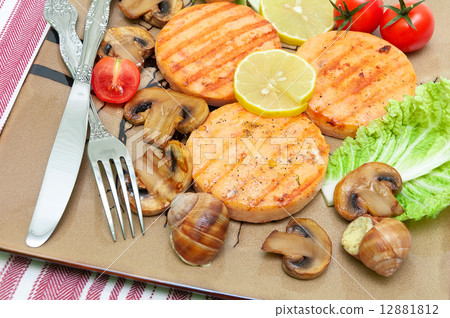 appetizing fried medallions of salmon, stuffed snails with mushr 12881812