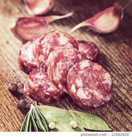 Sliced sausage spices and garlic on a board. Vintage retro hipst Sliced sausage spices and garlic on a board. Vintage retro hipst 12882028
