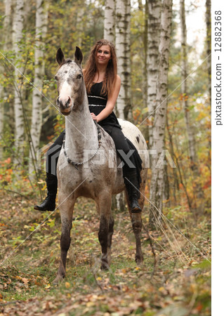 Young girl with appaloosa horse in autumn 12882368