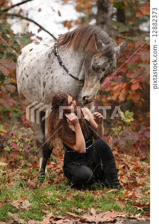 Pretty woman with appaloosa horse in autumn 12882373