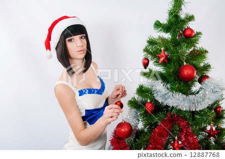 Beautiful girl in santa hat near a christmas tree with with Christmas toy 12887768