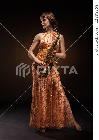 Sexual young woman posing with saxophone at studio 12888358