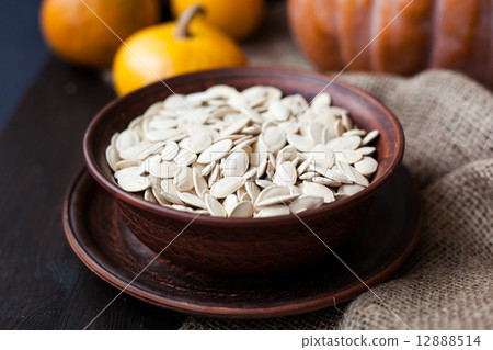 Bowl with toasted pumpkin seeds and wooden spoon Bowl with toasted pumpkin seeds and wooden spoon 12888514