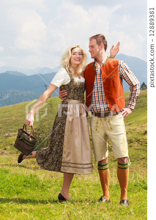 Bavarian couple in fashionable leather pants and dirndl Bavarian couple in fashionable leather pants and dirndl 12889381