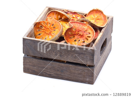 Slices of dried bael fruit in wooden box with copy space. 12889819