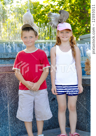 Little boy and girl with pigeons on their heads Little boy and girl with pigeons on their heads 12893011