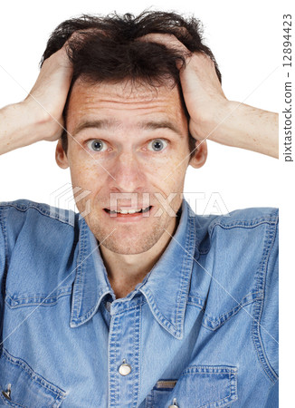 Confused young man has clasped hands a head 12894423
