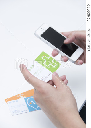 Men's hand making a telephone reservation with a medical examination ticket 12909060