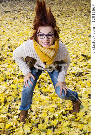 Young woman posing with hair in autumn leaves Young woman posing with hair in autumn leaves 12911667