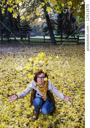 Young caucasian woman throwing yellow leaves Young caucasian woman throwing yellow leaves 12911670