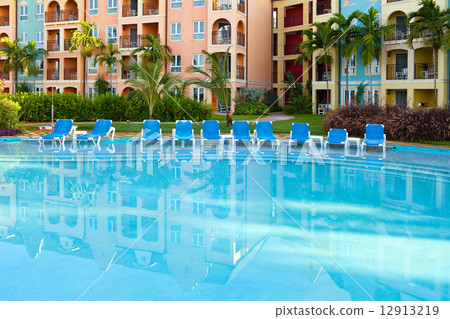 Empty chaise lounges near pool Empty chaise lounges near pool 12913219
