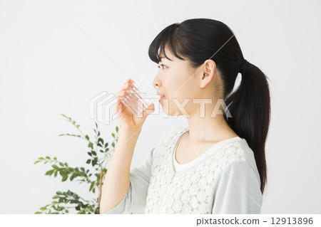 一個年輕的女人喝礦泉水 12913896