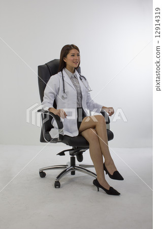 Asian medical doctor seated in high back chair 12914319