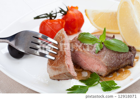 Grilled meat and spices lie on a board 12918071