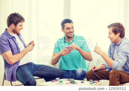 happy three male friends playing poker at home 12920512