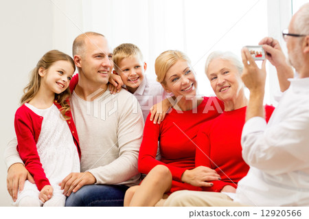 smiling family with camera at home 12920566