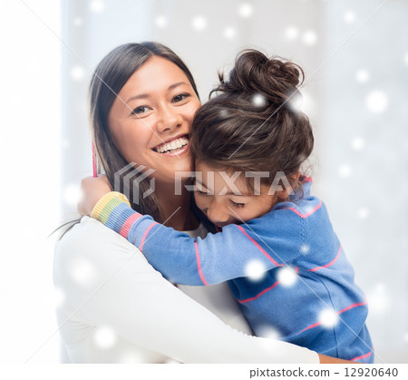 smiling little girl and mother hugging indoors 12920640