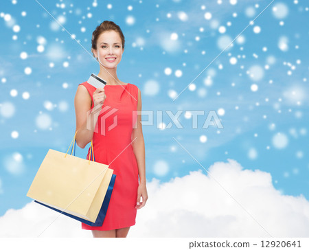 smiling woman with shopping bags and plastic card 12920641
