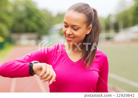smiling woman running on track outdoors 12920642