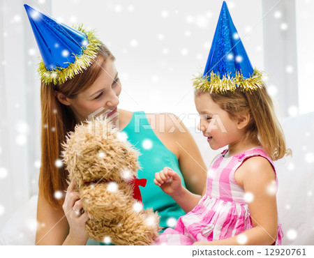 mother and daughter in party hats with toy 12920761