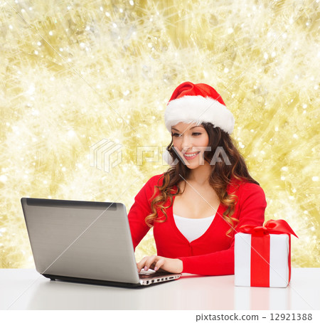 smiling woman with gift box and laptop 12921388