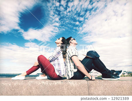 teenagers sitting back to back 12921389