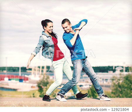 couple of teenagers dancing outside 12921804