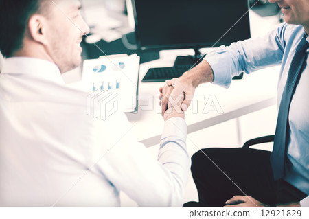 businessmen shaking hands in office 12921829
