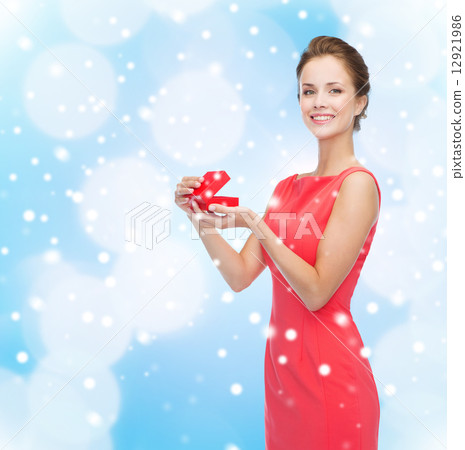 smiling young woman in red dress with gift box smiling young woman in red dress with gift box 12921986