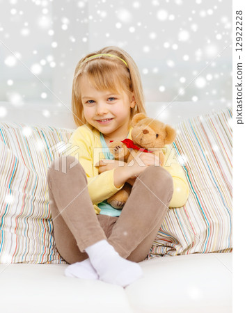 smiling girl with teddy bear sitting on sofa smiling girl with teddy bear sitting on sofa 12922228