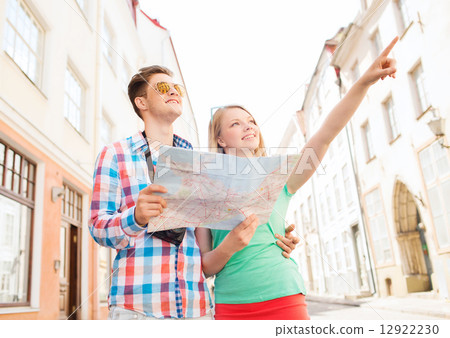 smiling couple with map and photo camera in city smiling couple with map and photo camera in city 12922230