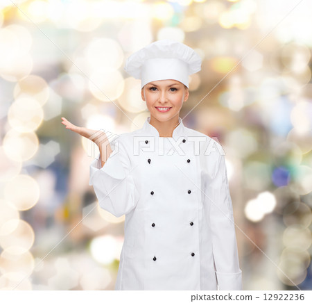 smiling female chef holding something on hand smiling female chef holding something on hand 12922236