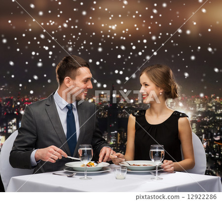 smiling couple eating main course at restaurant smiling couple eating main course at restaurant 12922286
