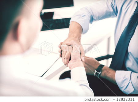 businessmen shaking hands in office 12922331