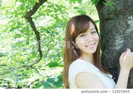 與一棵新鮮的綠色樹的公平的美好的擁抱 12925645