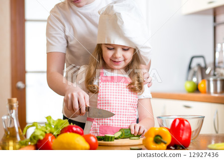 mother and daughter cooking and cutting vegetables on kitchen mother and daughter cooking and cutting vegetables on kitchen 12927436