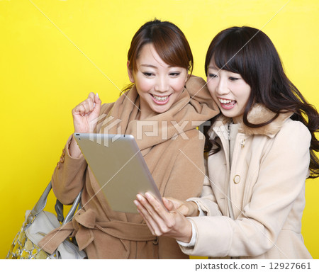 Girls searching for shops on tablet PC 12927661