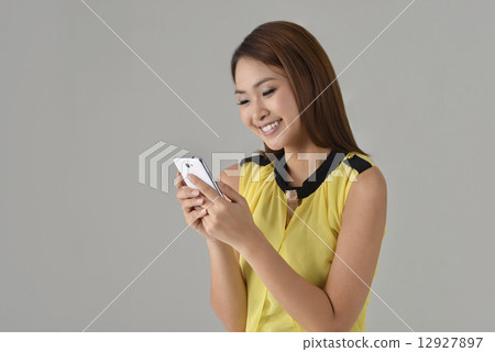 Asian lady texting with mobile phone Asian lady texting with mobile phone 12927897