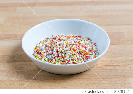 Sugar sprinkles in a bowl on wood Sugar sprinkles in a bowl on wood 12928965