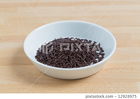 Sprinkles in a bowl on wood 12928975