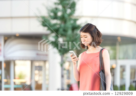 A woman looking at a smartphone and making a blister 12929809