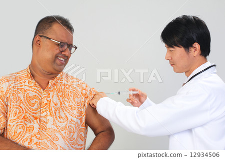 A doctor giving vaccination to a patient A doctor giving vaccination to a patient 12934506