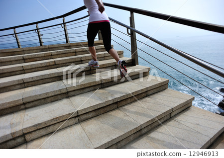 healthy lifestyle sports woman running on stone stairs seaside  12946913