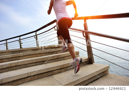 healthy lifestyle sports woman running on stone stairs seaside  12946921
