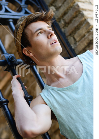 Attractive young handsome man, model of fashion in urban backgro 12947512