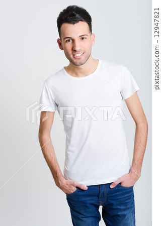 Smiling young man standing against white background Smiling young man standing against white background 12947821