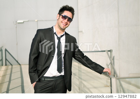 Portrait of a handsome young businessman smiling with sunglasses Portrait of a handsome young businessman smiling with sunglasses 12947882